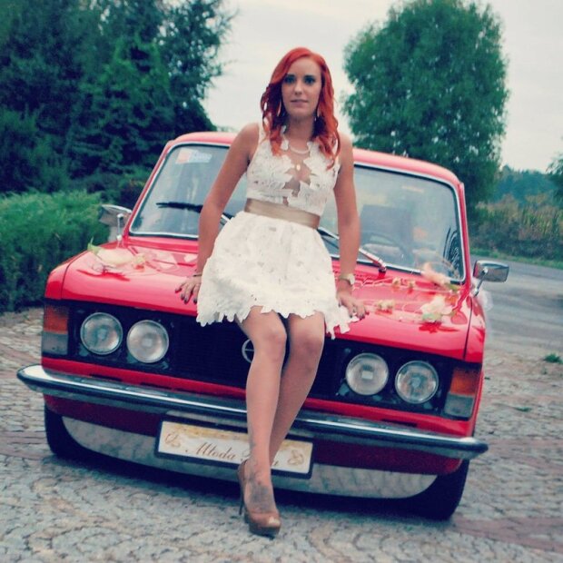 Redhead chick posing outdoors with vintage car